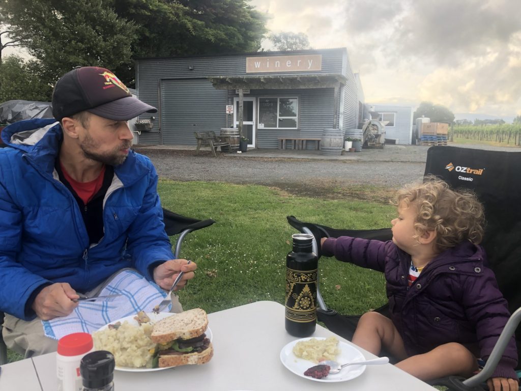 Vegan family eating burgers outside while traveling