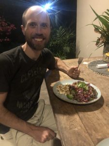 Vegan man eating stir-fry that was made while traveling