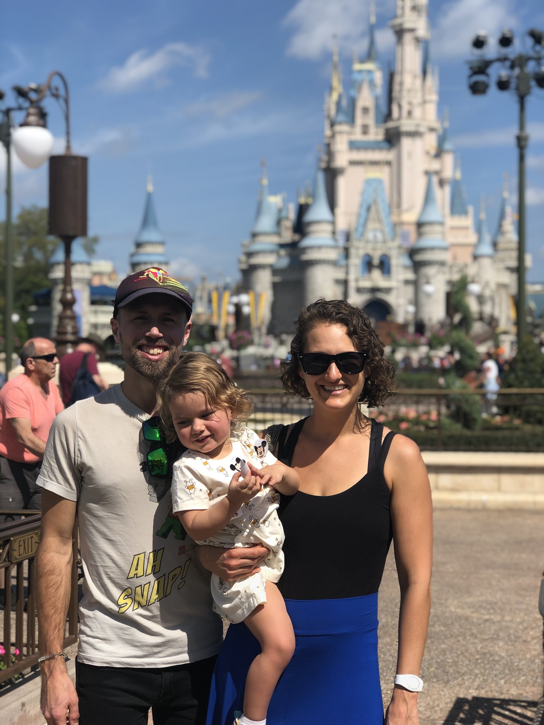 Family in Magic Kingdom with a toddler in front of Cinderella's Castle