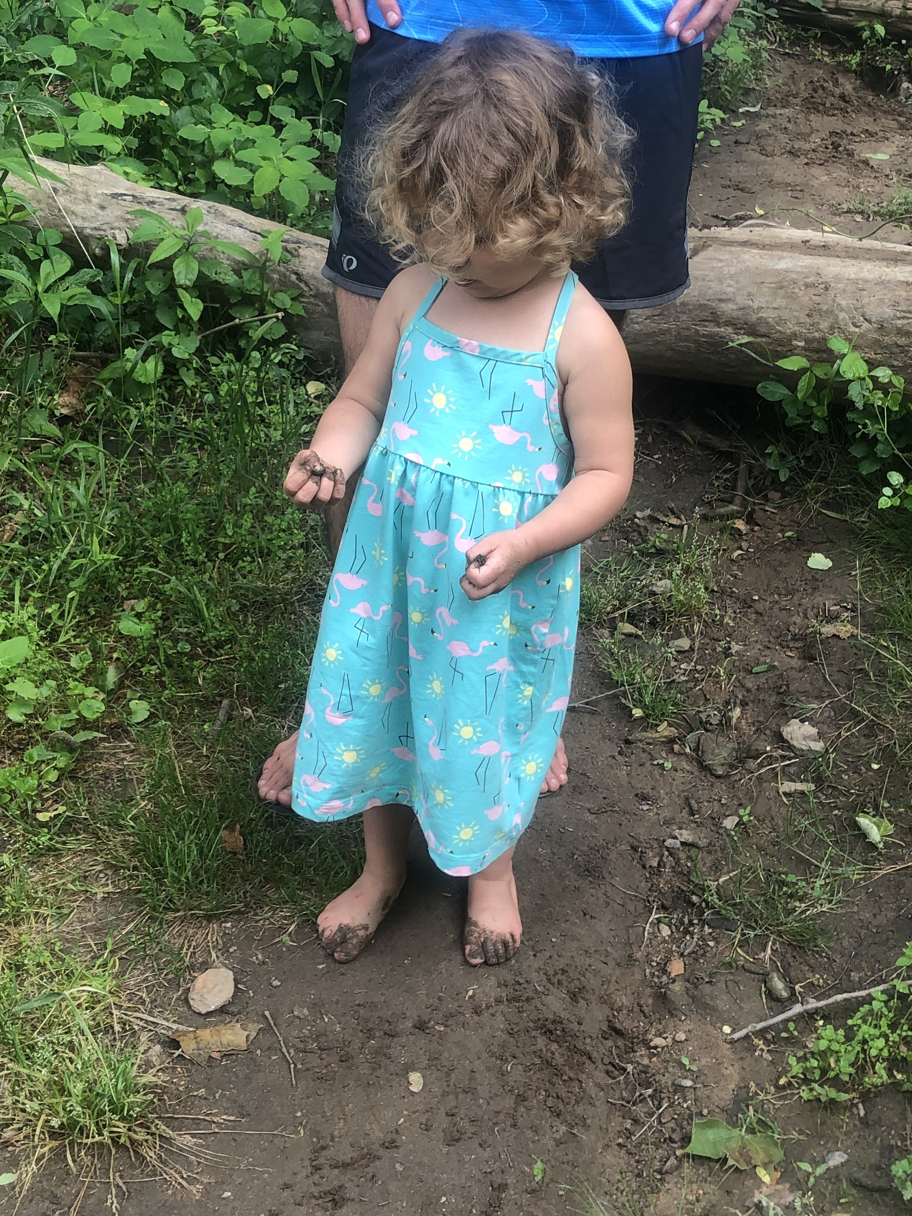 Toddler on a road trip getting muddy on a hiking break