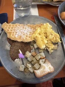 Vegan and Gluten Free breakfast foods at Akershus in Disney World include waffles, vegan scrambled eggs, breakfast sausage, and herby potatoes.