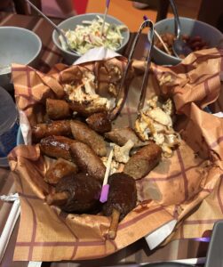 Vegan and gluten free platter at Roundup Rodeo in Disney World containing sausages, cauliflower, and vegan ribs