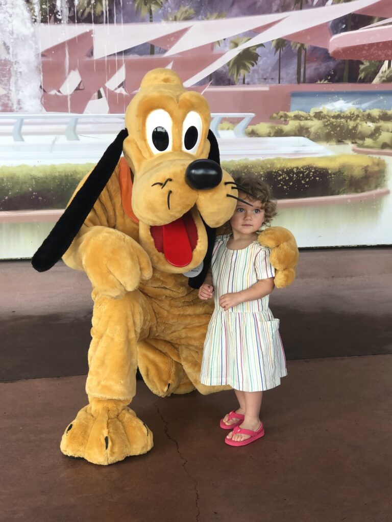 Pluto and a toddler meet at EPCOT