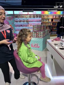 Girl gets her hair temporarily colored for free at Hamleys in London