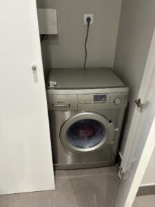 Washing machine at Espais Blaus apartment in Barcelona